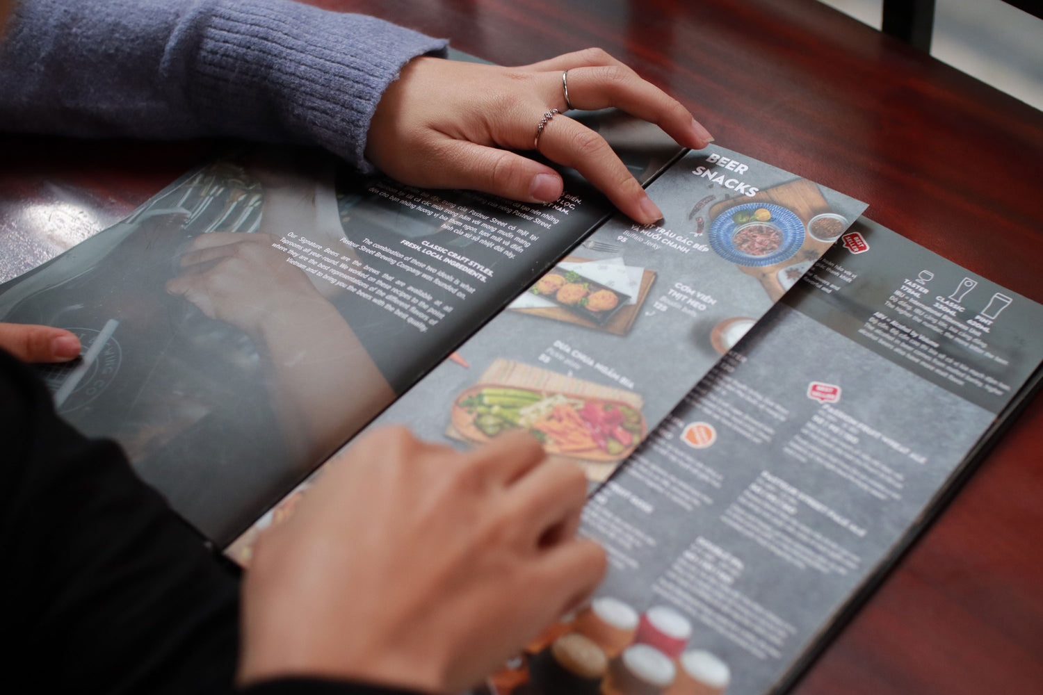 Photo by Khanh Tu Nguyen Huy on Unsplash. Patrons look through a menu.